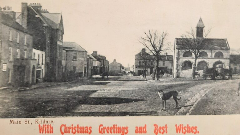 Postcard of Main Street, Kildare Town (Square) with Christmas Greetings added in red font.